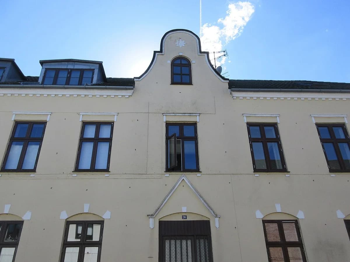 Facade of a typical Danish building with cream walls and dark brown windows