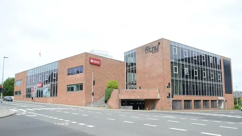 Brick commercial building with glass windows and signage at urban street corner