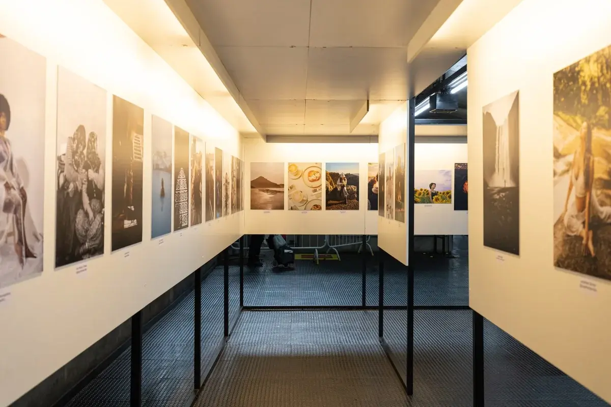 Indoor gallery displaying diverse photographic prints on panels