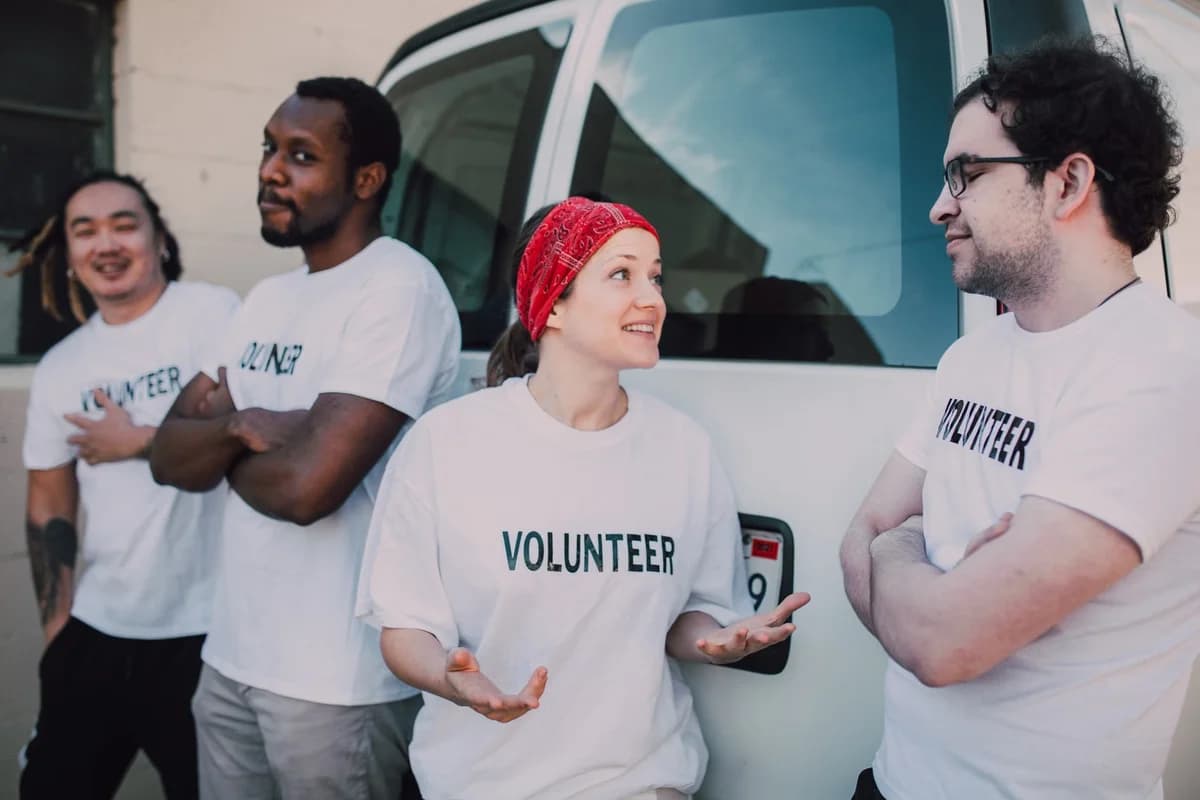 Four volunteers talking beside a van.