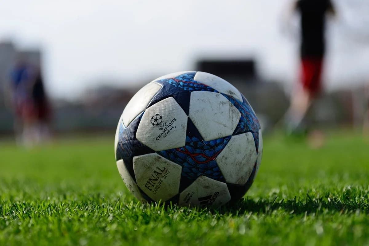 A soccer ball on a green field in daylight.