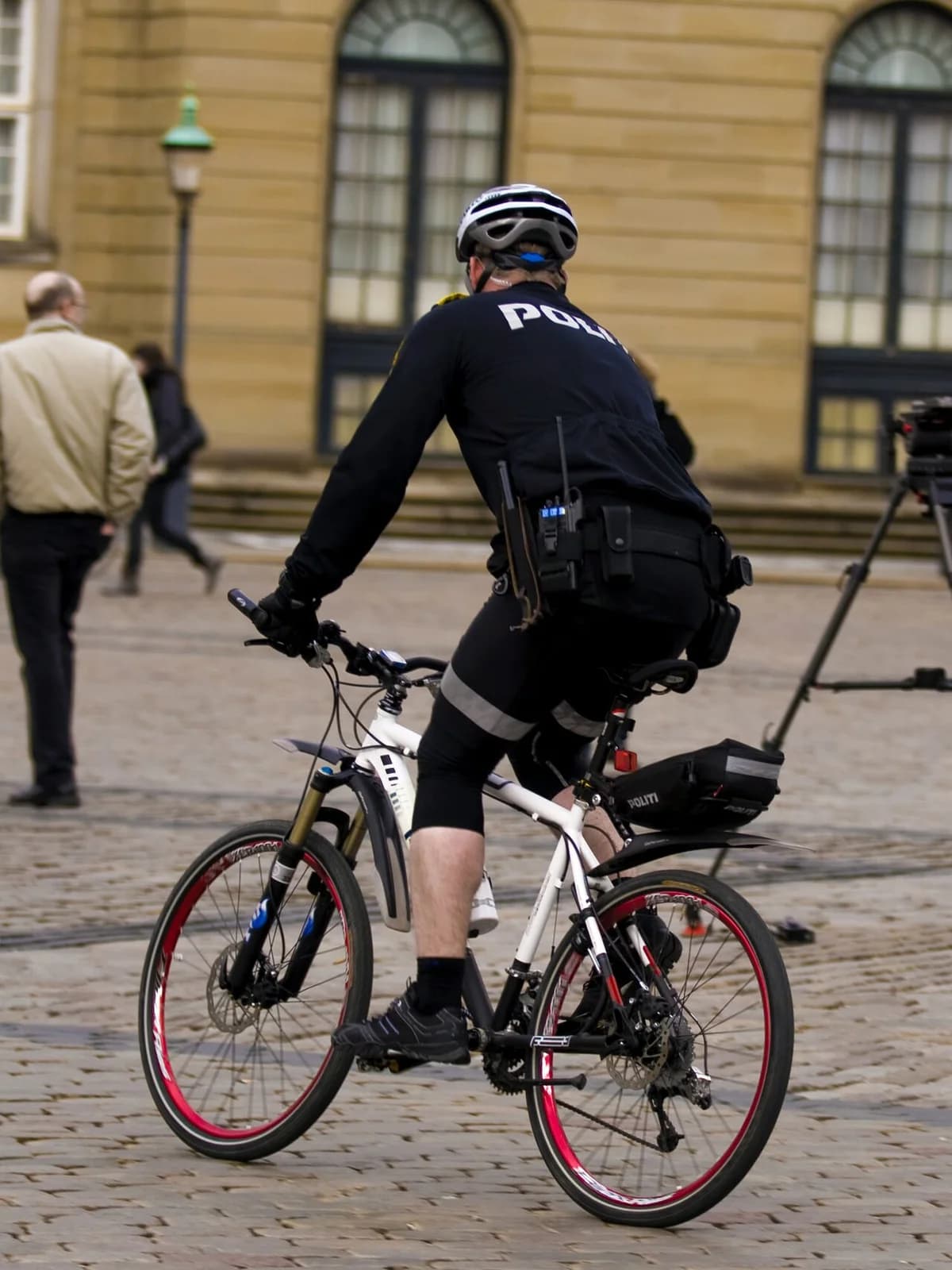 A Danish police officer rides a bicycle during a city patrol.