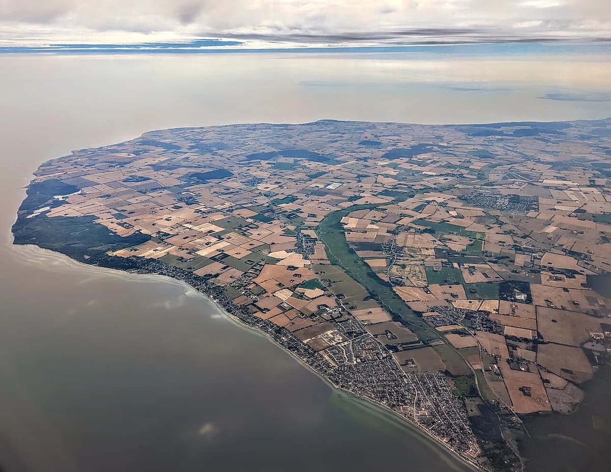 Aerial view of farmland and coastal residential areas beside Køge Bay.