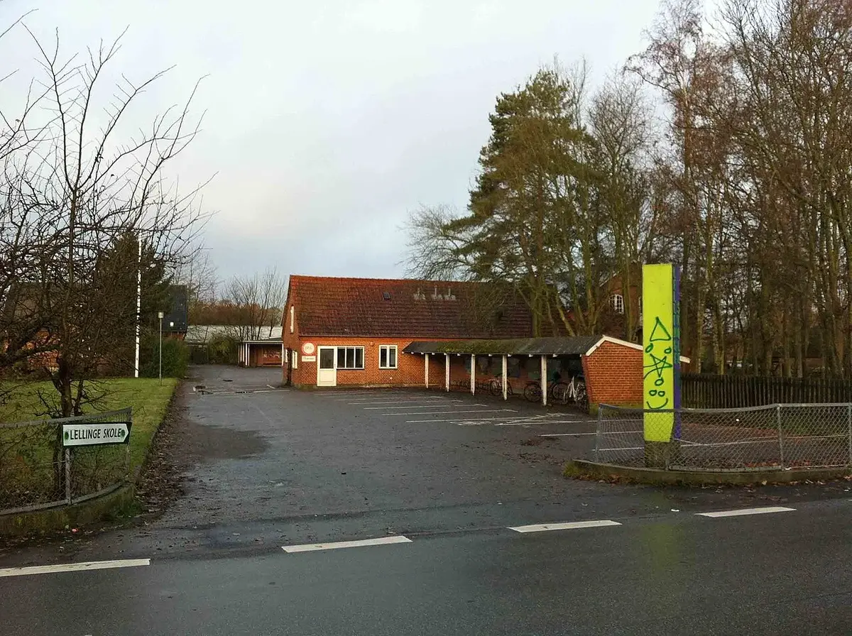 A small brick building labeled Lellinge School, surrounded by bare trees.
