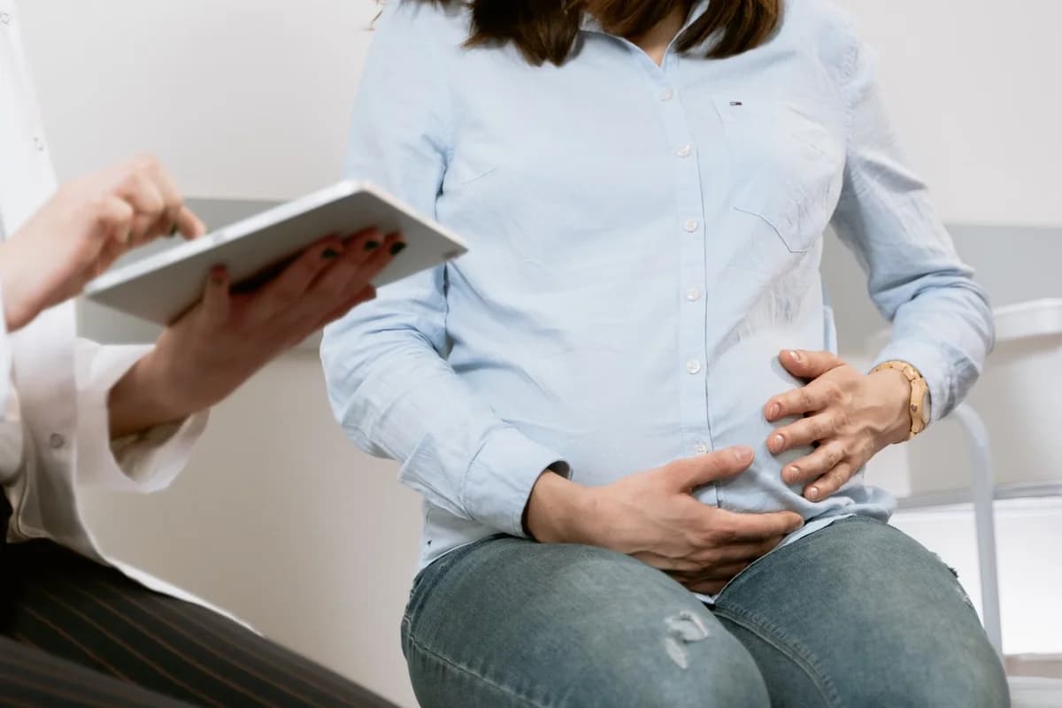 Pregnant woman talking with a doctor in a clinic.