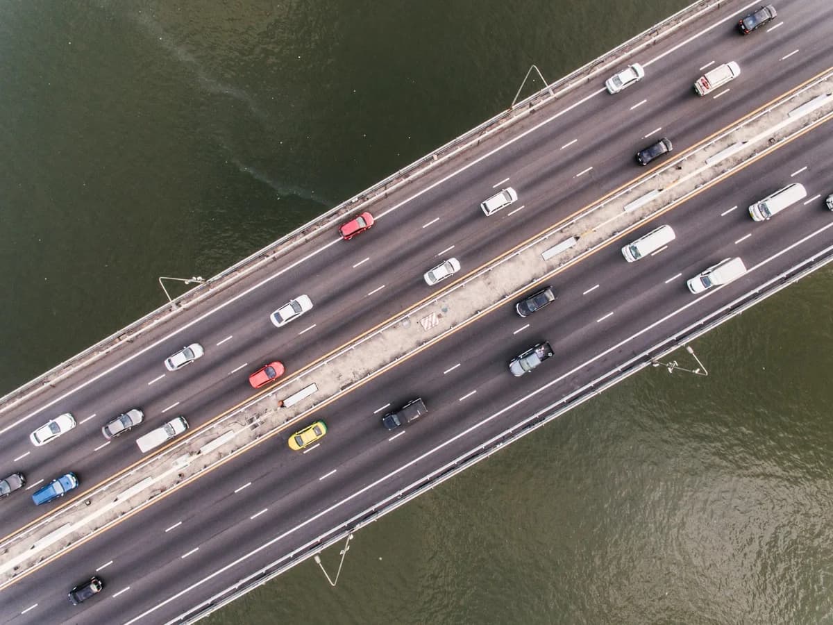 Aerial view of cars driving on a bridge over water.