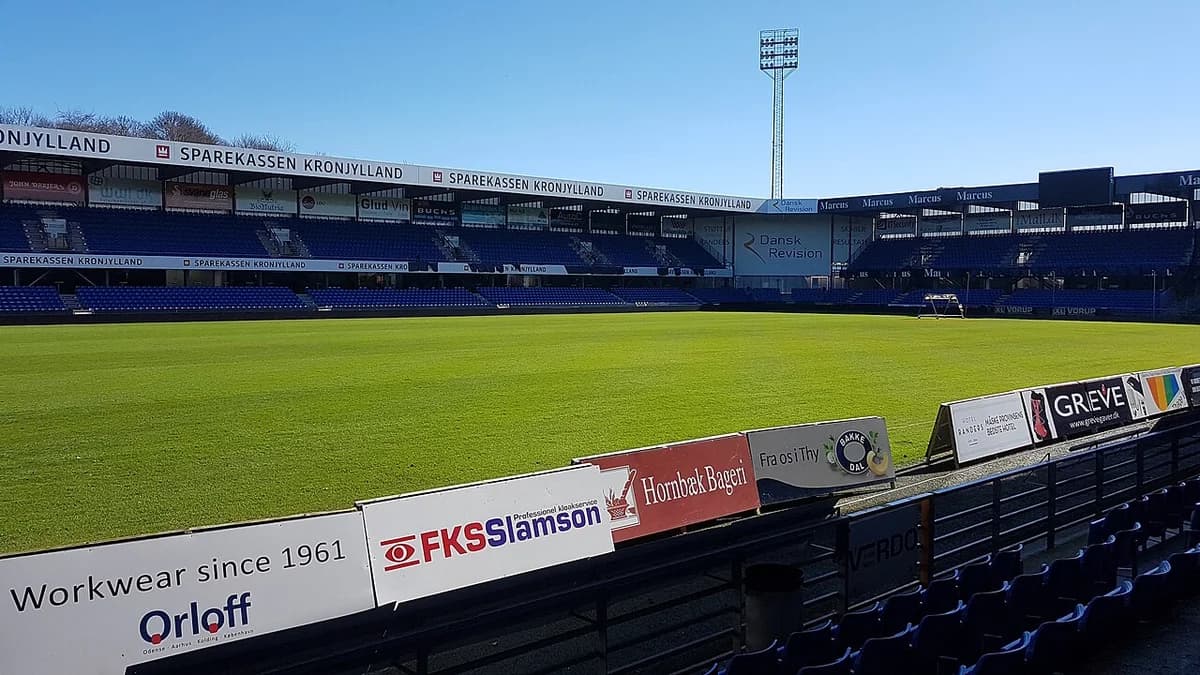 Green football pitch and empty stands of Randers Stadion in Denmark