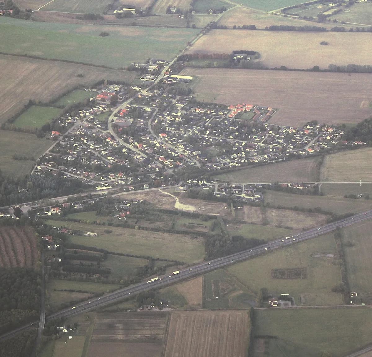 Aerial view of a small village surrounded by farmland.