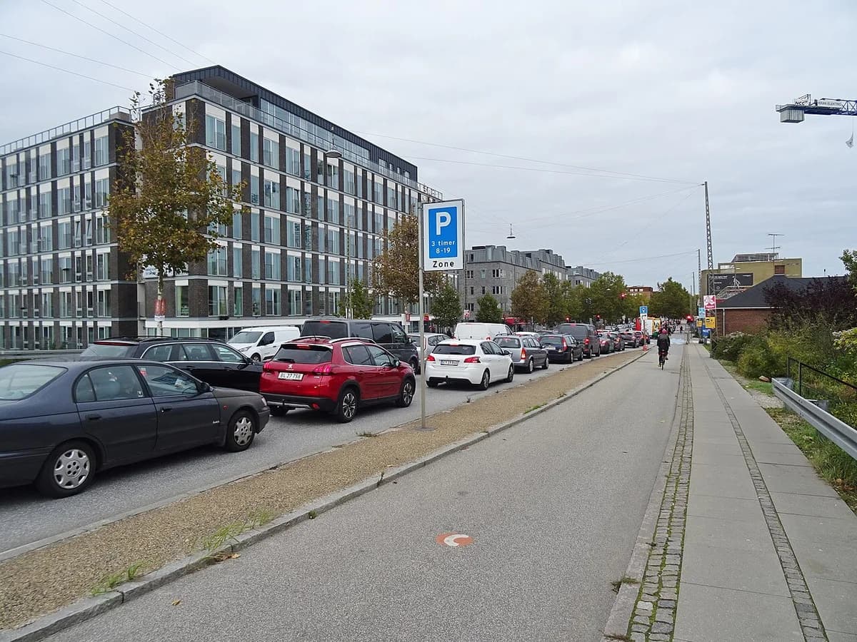 Heavy traffic beside a bike lane on a street in Copenhagen.